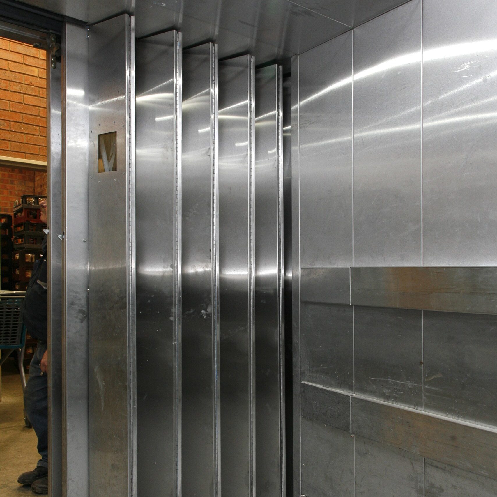 Stainless-steel goods-lift cabin with protective rails at Ballito Junction Regional Mall.