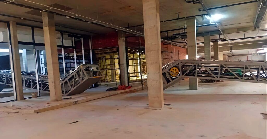 Escalator trusses staged across the unfinished Paarl mall interior.