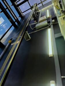 Guide rails and vertical lighting inside the glazed passenger-elevator shaft.